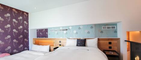 Una habitación de hotel moderna con una cama grande, cabecero de madera y una pared decorativa con motivos florales.