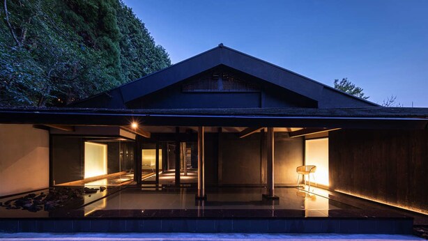 A modern house with a flat roof, large glass windows, and a stone pathway leading to the entrance. - Mifuneyama Rakuen Hotel (Takeo)