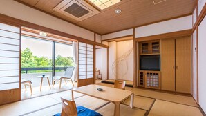 A traditional Japanese room with tatami flooring, a low table, and sliding doors. - Mifuneyama Rakuen Hotel (Takeo)
