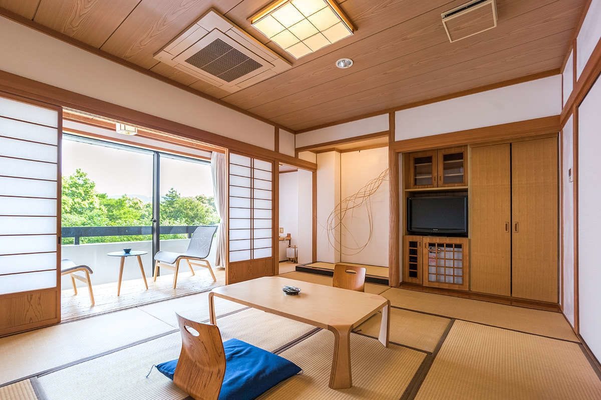 A traditional Japanese room with tatami flooring, a low table, and sliding doors.
