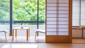 A traditional Japanese room with tatami flooring, a low table, and a sliding door with shoji screens. - Mifuneyama Rakuen Hotel (Takeo)