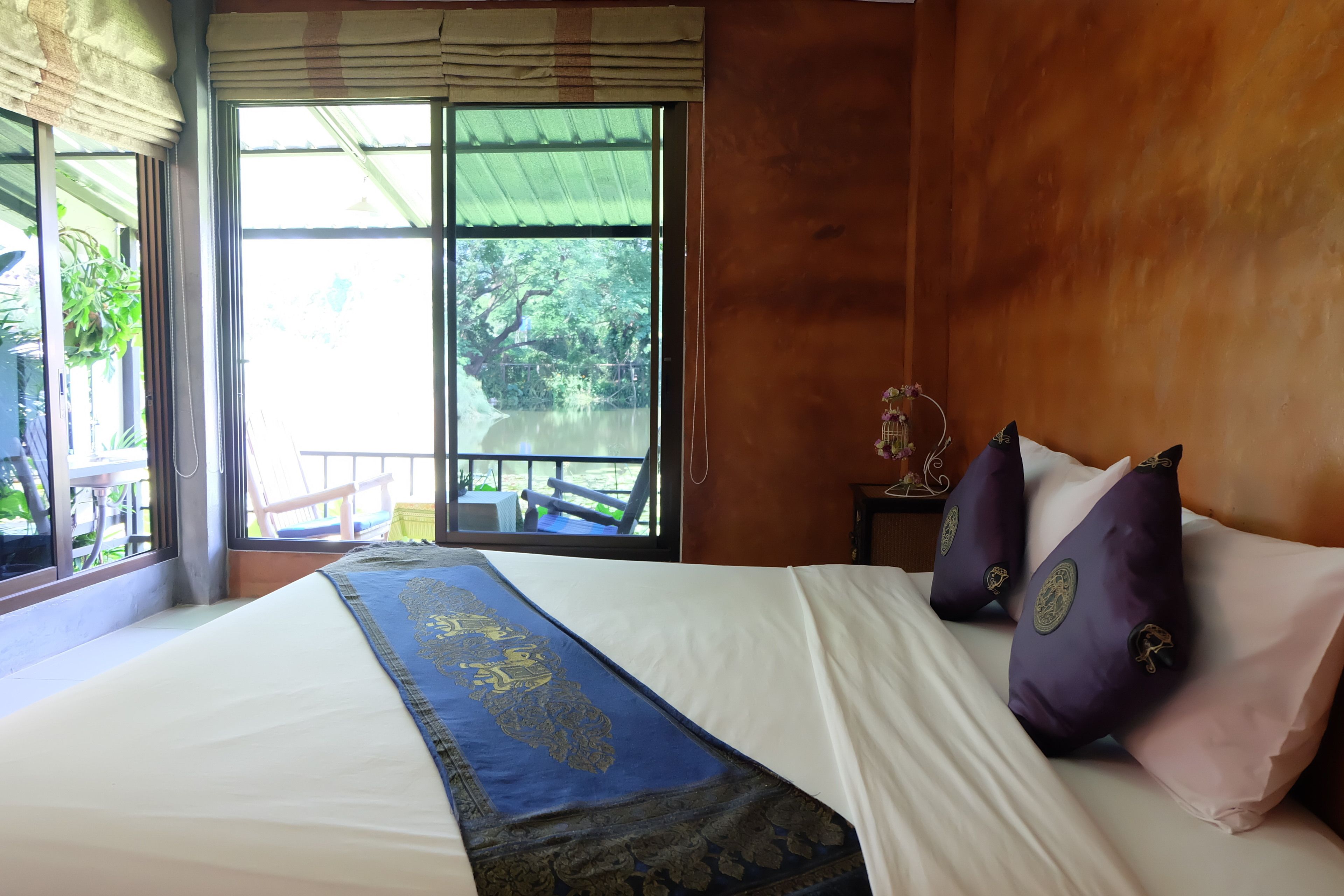 Una habitación de hotel con una cama grande, vistas a un balcón y una pared de madera.