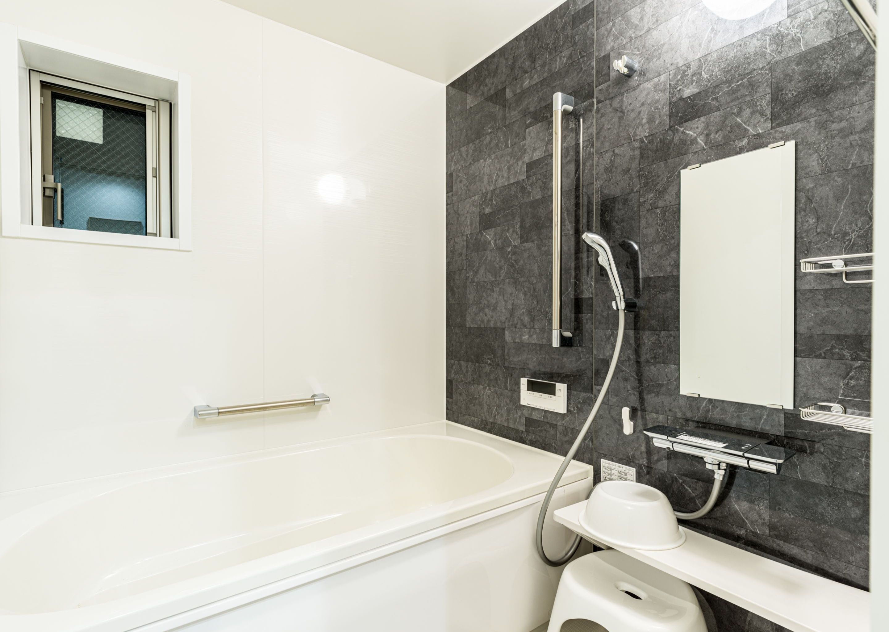 Ein modernes Badezimmer mit Badewanne, Dusche inklusive Handbrause, Toilette und Waschbecken.