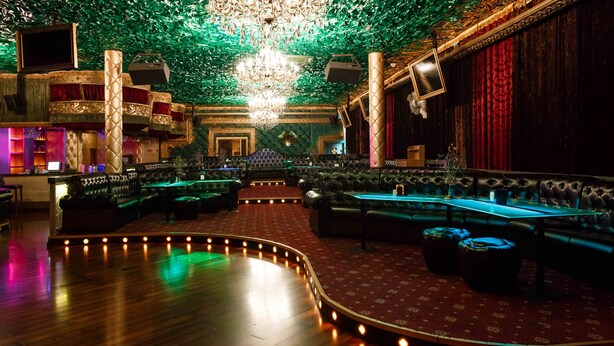 A luxurious interior with a grand chandelier, plush seating, and a stage area. - Grand Opera Hotel (Almaty)