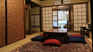 Ein traditioneller japanischer Raum mit Tatami-Boden, einem niedrigen Tisch und Shoji-Schirmwänden.