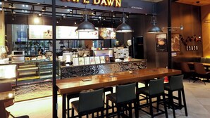A café with a wooden counter, hanging pendant lights, and a menu board. - Sea Cruise Hotel (Sokcho)