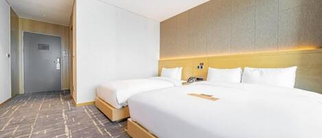 A hotel room with a large bed, a bedside table, and a headboard.
