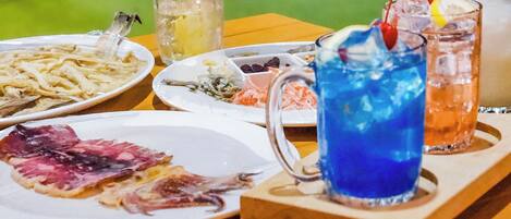 A table with various plates of food and drinks.