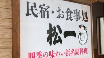 Un letrero con caracteres japoneses y un pingüino de dibujo animado.