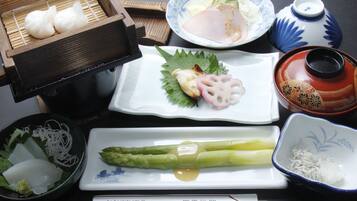 A variety of Japanese dishes including sushi, sashimi, and pickled vegetables on a table.