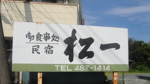Letrero de restaurante con caracteres japoneses y un número de teléfono.