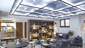 Un salón amplio con una gran estantería, un sofá y un comedor.
