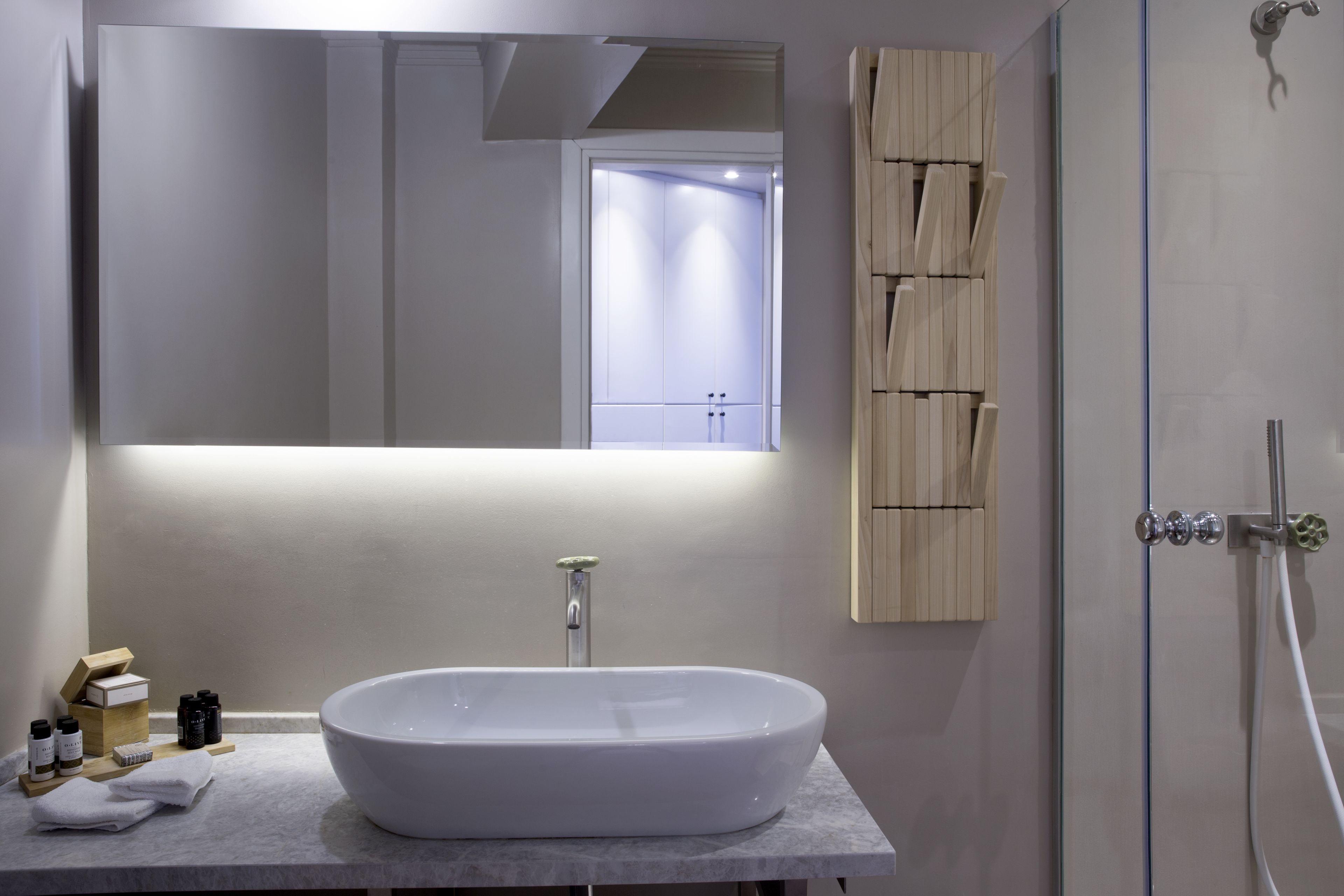 Un baño moderno con una bañera independiente, un espejo grande y un mueble de madera.