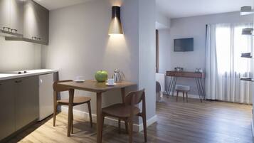 Une cuisine moderne avec des meubles de rangement en bois, une table à manger avec des chaises et un luminaire suspendu.