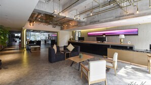 A modern lobby with a reception desk, seating area, and a large window overlooking the interior. - City Inn OCT Loft Branch (Shenzhen)