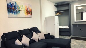Ein modernes Wohnzimmer mit einem Ecksofa, einem Flachbildfernseher und einem Stadtbild.