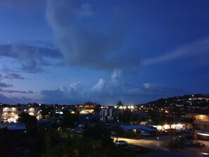A nighttime view of a residential area with buildings, cars, and streetlights. - Clear Water Hotel (Saipan)