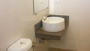 A bathroom with a toilet, a sink, and a mirror. - Jesus Holiday Home Resort (Candolim)