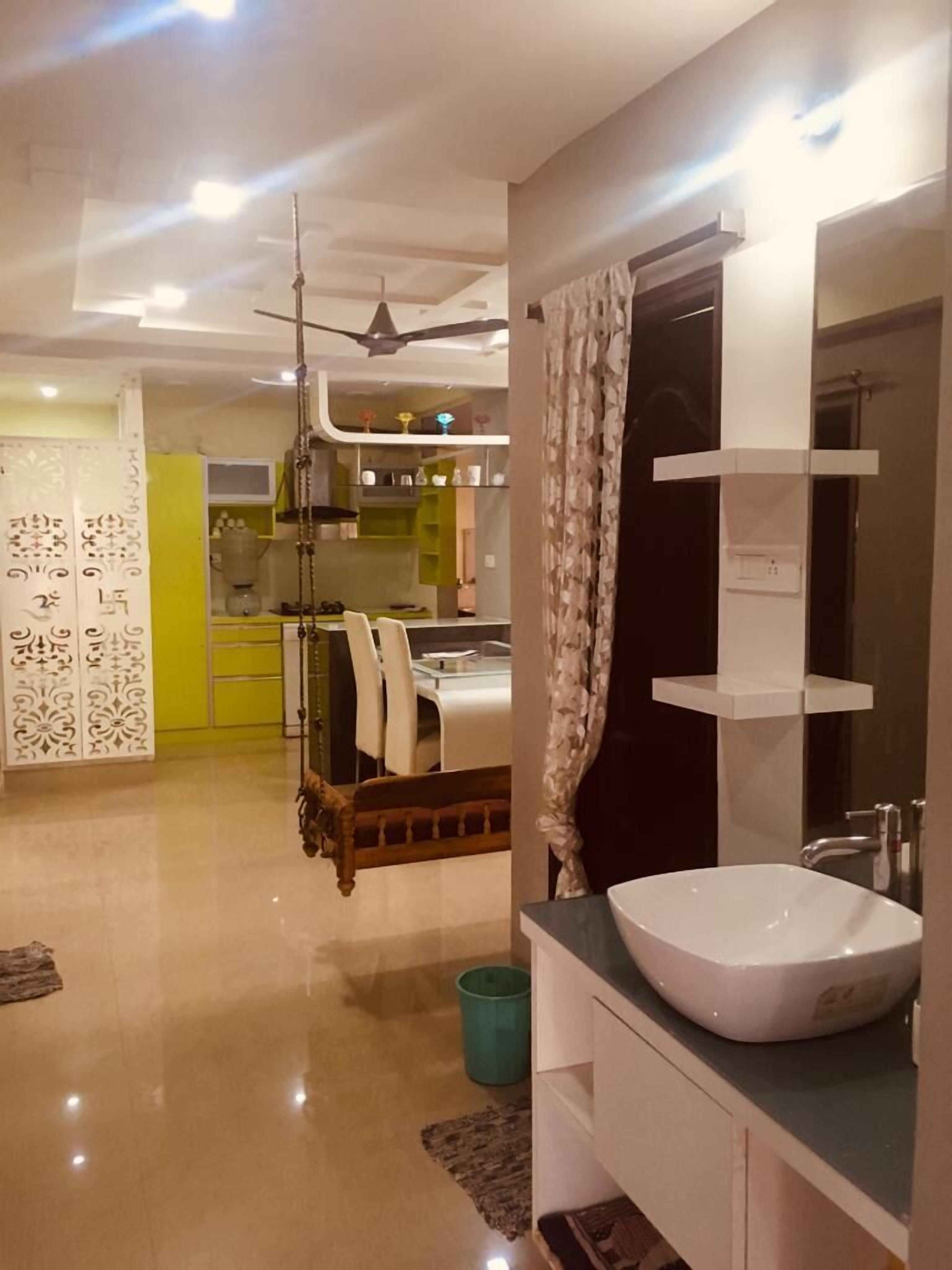 A modern bathroom with a large sink, a mirror, and a ceiling fan.