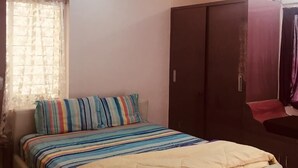Ein Schlafzimmer mit einem Bett, einem Deckenventilator und einem Kleiderschrank.