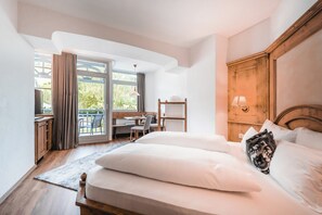 Un dormitorio con una cama grande, un escritorio y una silla cerca de una ventana con cortinas.