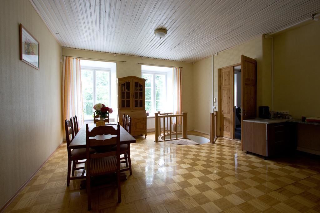Un comedor con piso a cuadros, mobiliario de madera y vista al exterior a través de amplios ventanales.