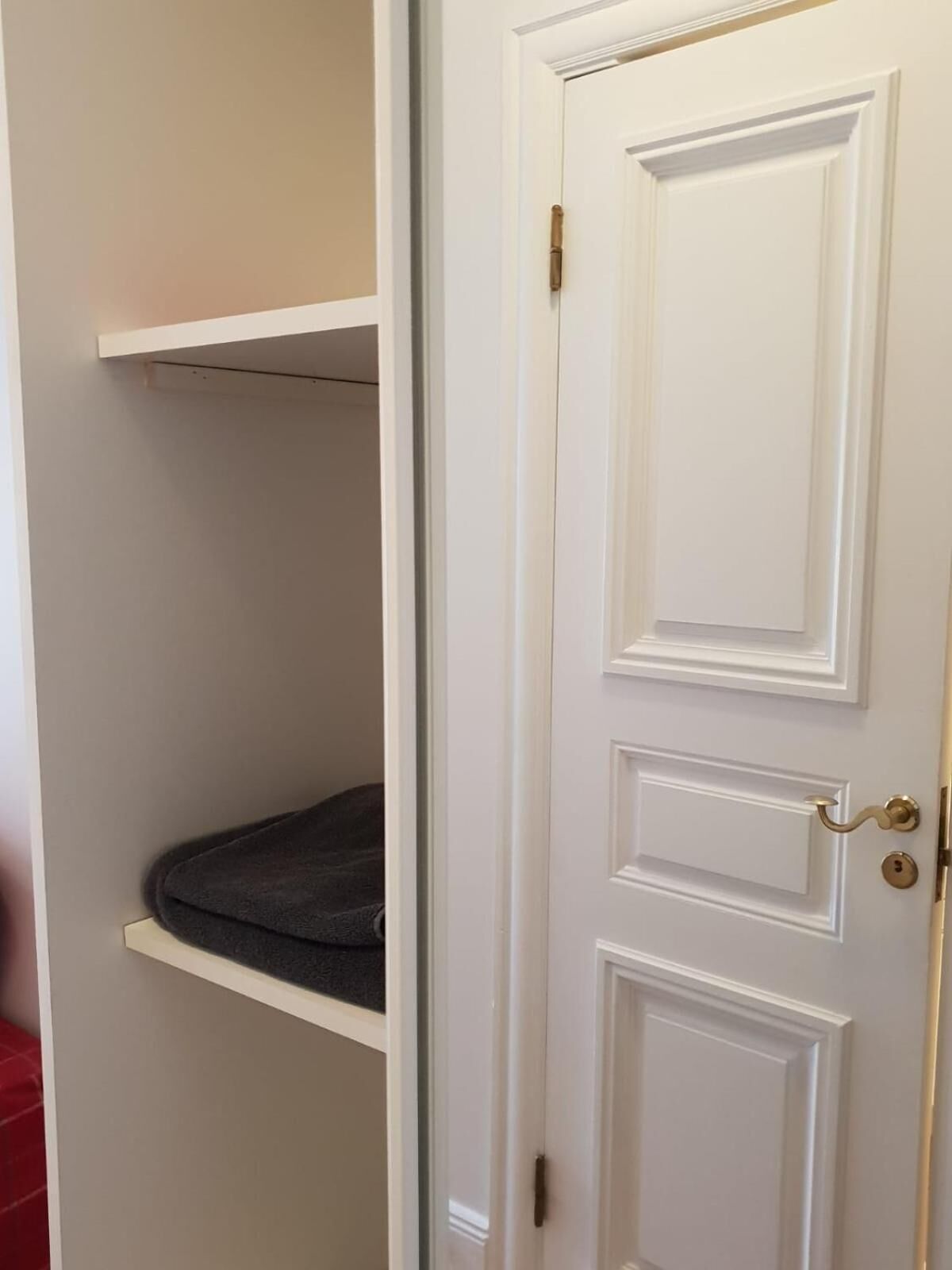 A white door with a gold handle and a keyhole.