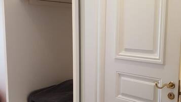 A white door with a gold handle and a keyhole.