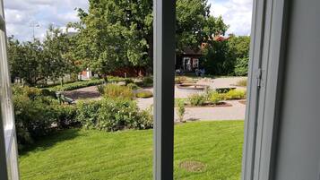 A view of a garden with a fountain, neatly trimmed hedges, and a lawn.