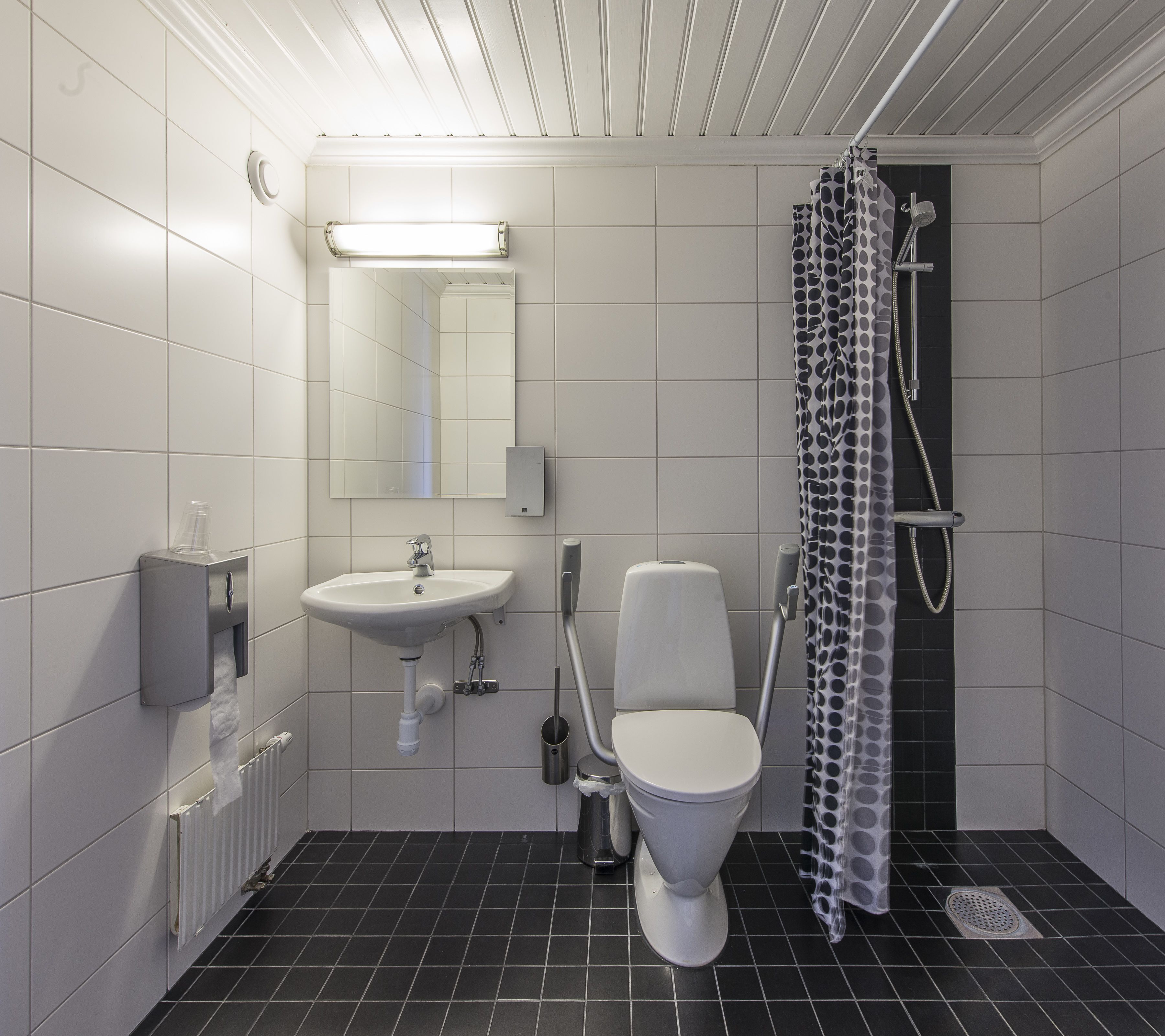 A modern bathroom with a toilet, sink, and shower.