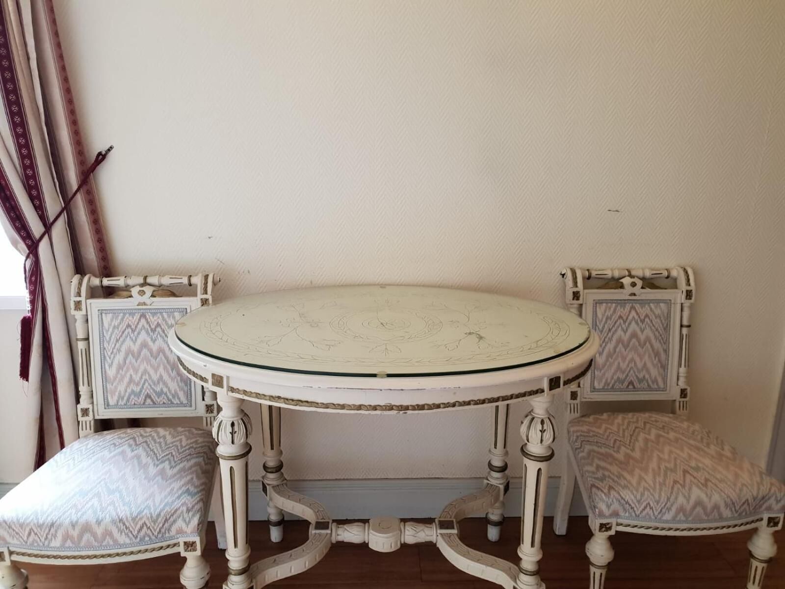 A round table with two chairs, each with a zigzag patterned cushion.