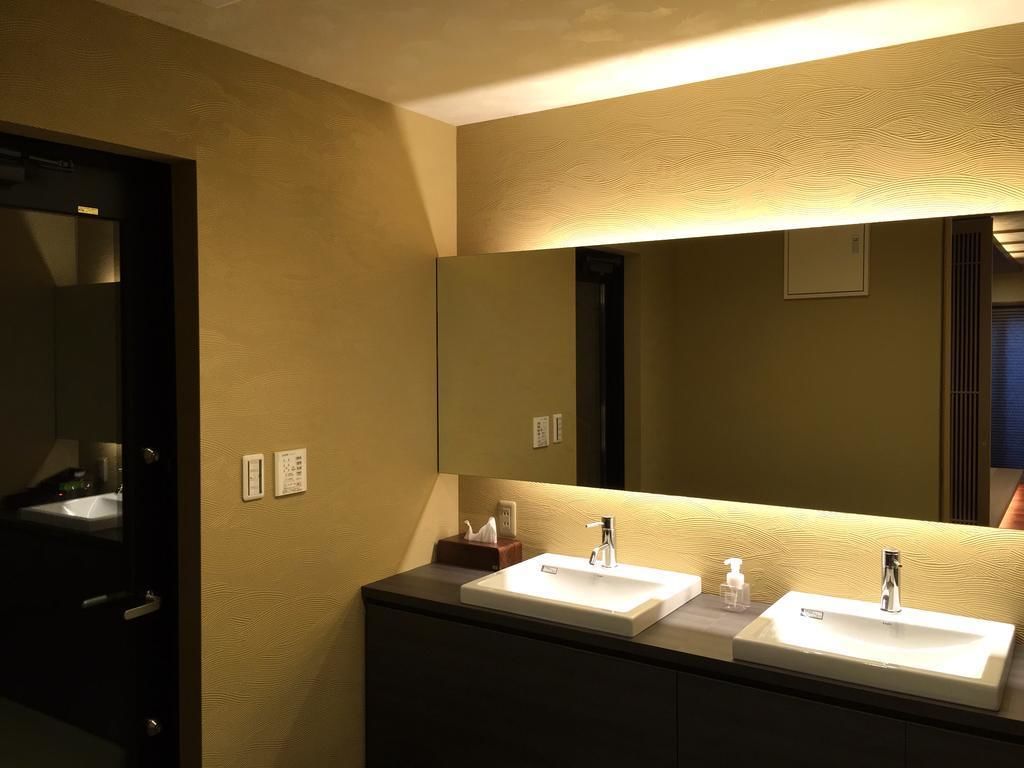 Une salle de bain avec deux lavabos, un grand miroir et un porte-serviettes.