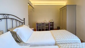 A hotel room with a bed, a desk, and a wardrobe. - B&B San Francesco (Siena)