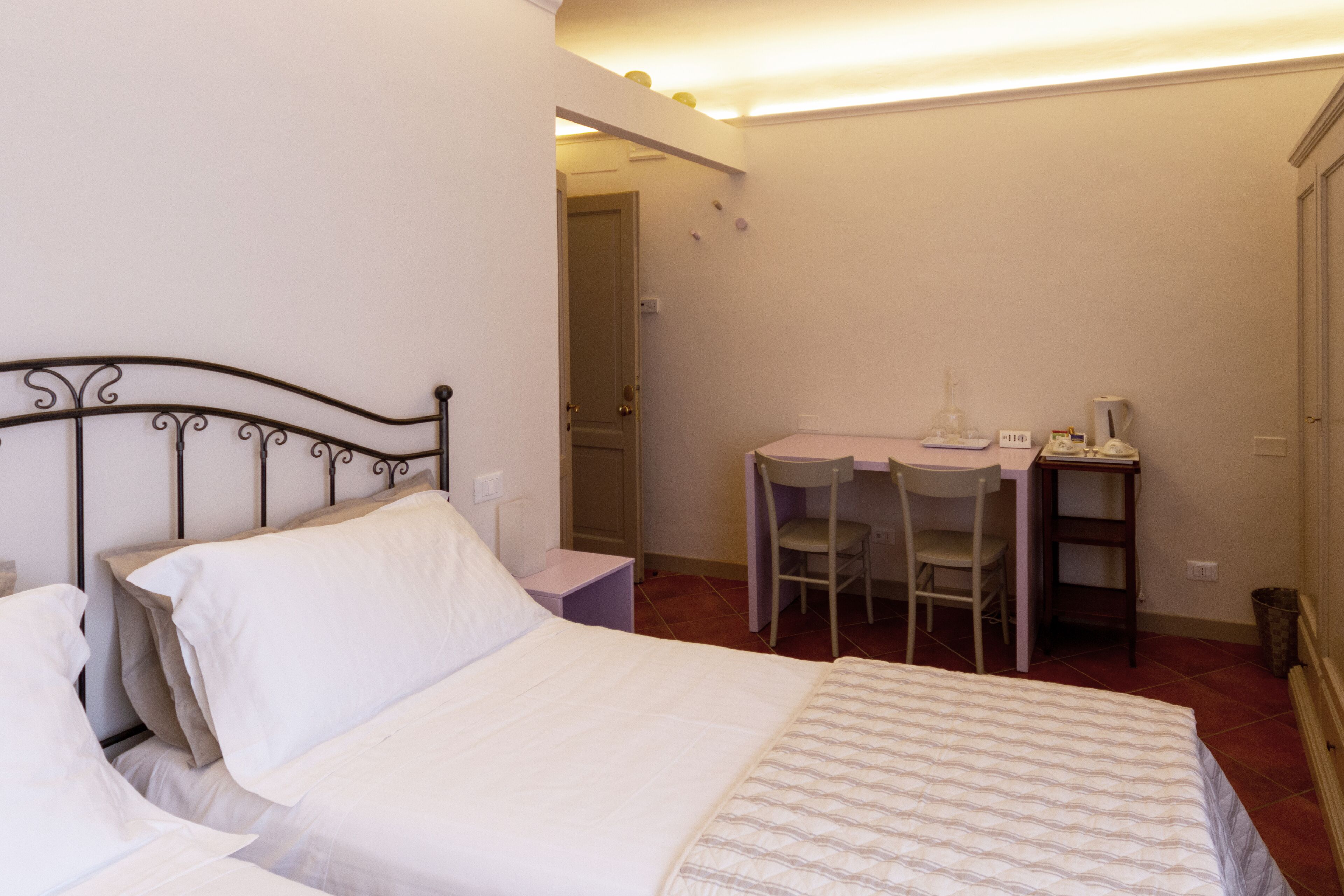 A bedroom with a bed, a desk, and a chair.