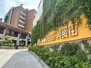 A building with a sign that reads 'DIE STREET' and a covered walkway with greenery. - City Inn Splendid China Branch (Shenzhen)