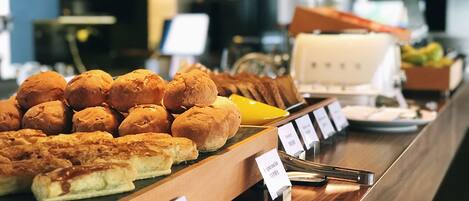 A buffet with various baked goods and a sign indicating a barbecue pork cake.