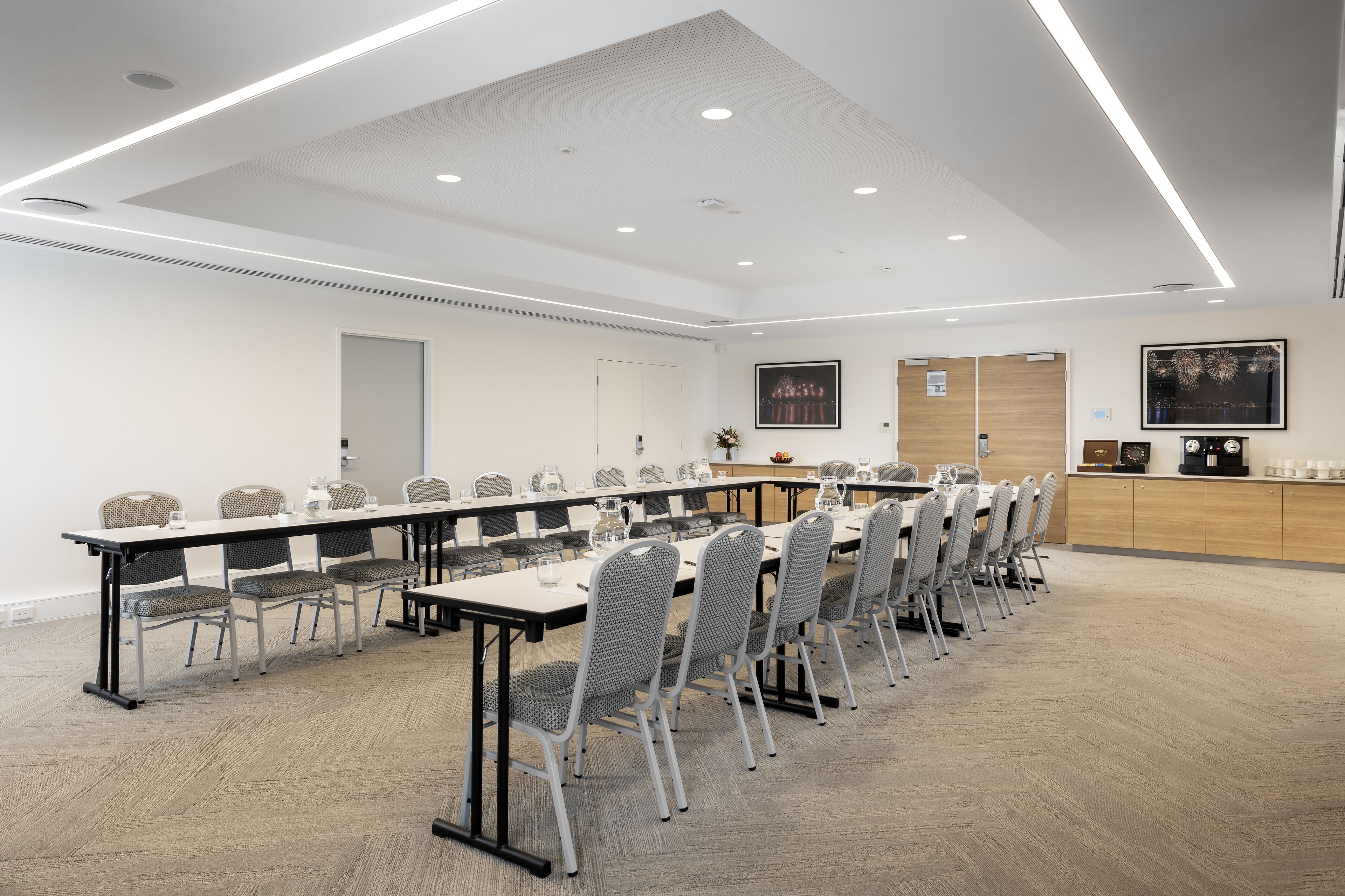 A conference room with a long table, chairs, and a podium.