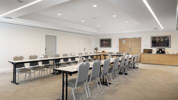 A conference room with a long table, chairs, and a podium.