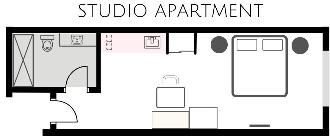 Un studio comprenant un coin cuisine, une salle de bain, un espace salon et un petit coin repas.