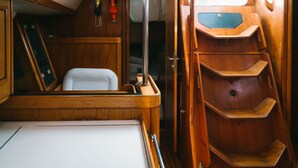 A compact cabin with a wooden interior, a small bed, a control panel, and a window. - Sheliak boat and breakfast (Catania)