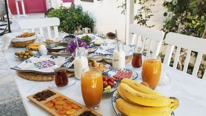 A table set with various foods and drinks, including fruits, bread, and beverages. - Aisem By Hire Alacati (Cesme)