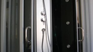 Een douche met een handdouche en een vastgeplaatste douchekop.