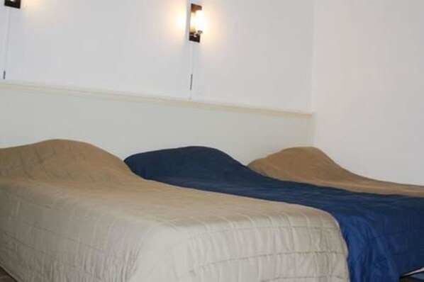 Una habitación con dos camas, cada una con un edredón de diferente color.