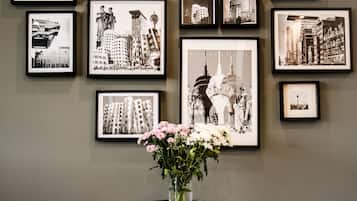A wall with multiple framed black and white photographs of cityscapes and architectural structures.