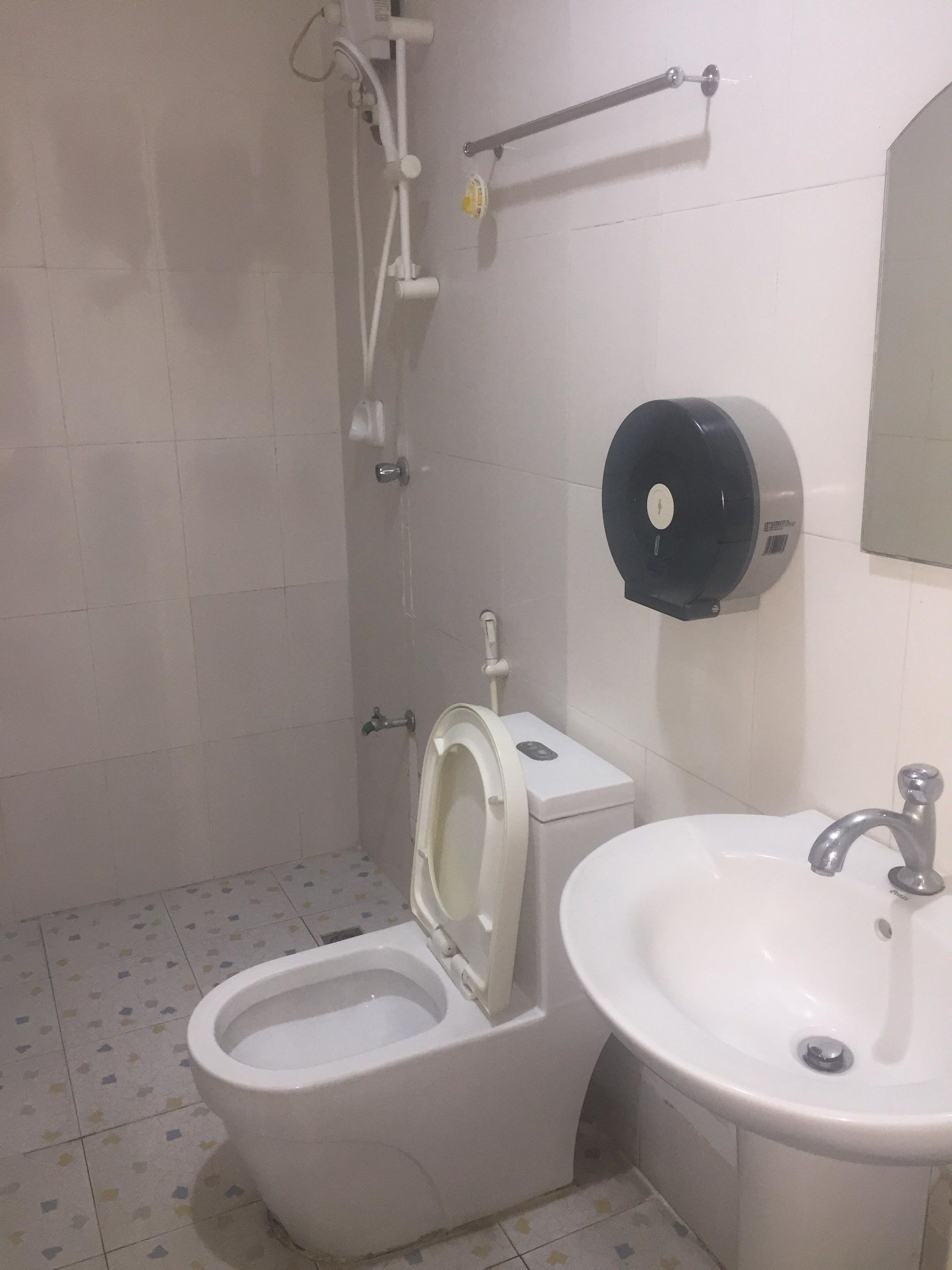 Ein Badezimmer mit Toilette, Waschbecken und Handtrockner.