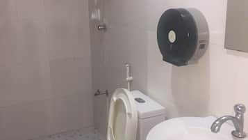 Ein Badezimmer mit Toilette, Waschbecken und Handtrockner.