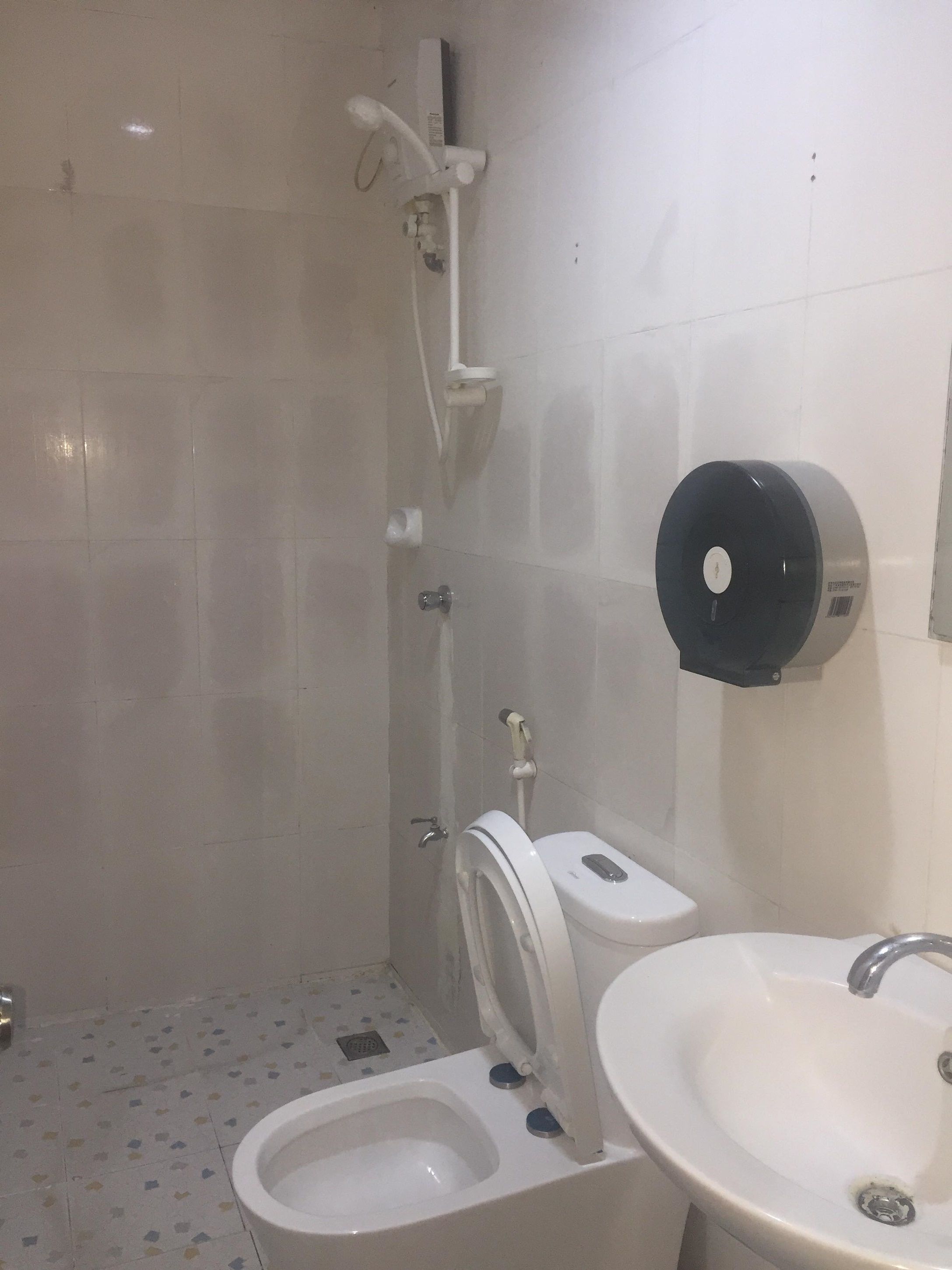 A bathroom with a toilet, sink, and shower.