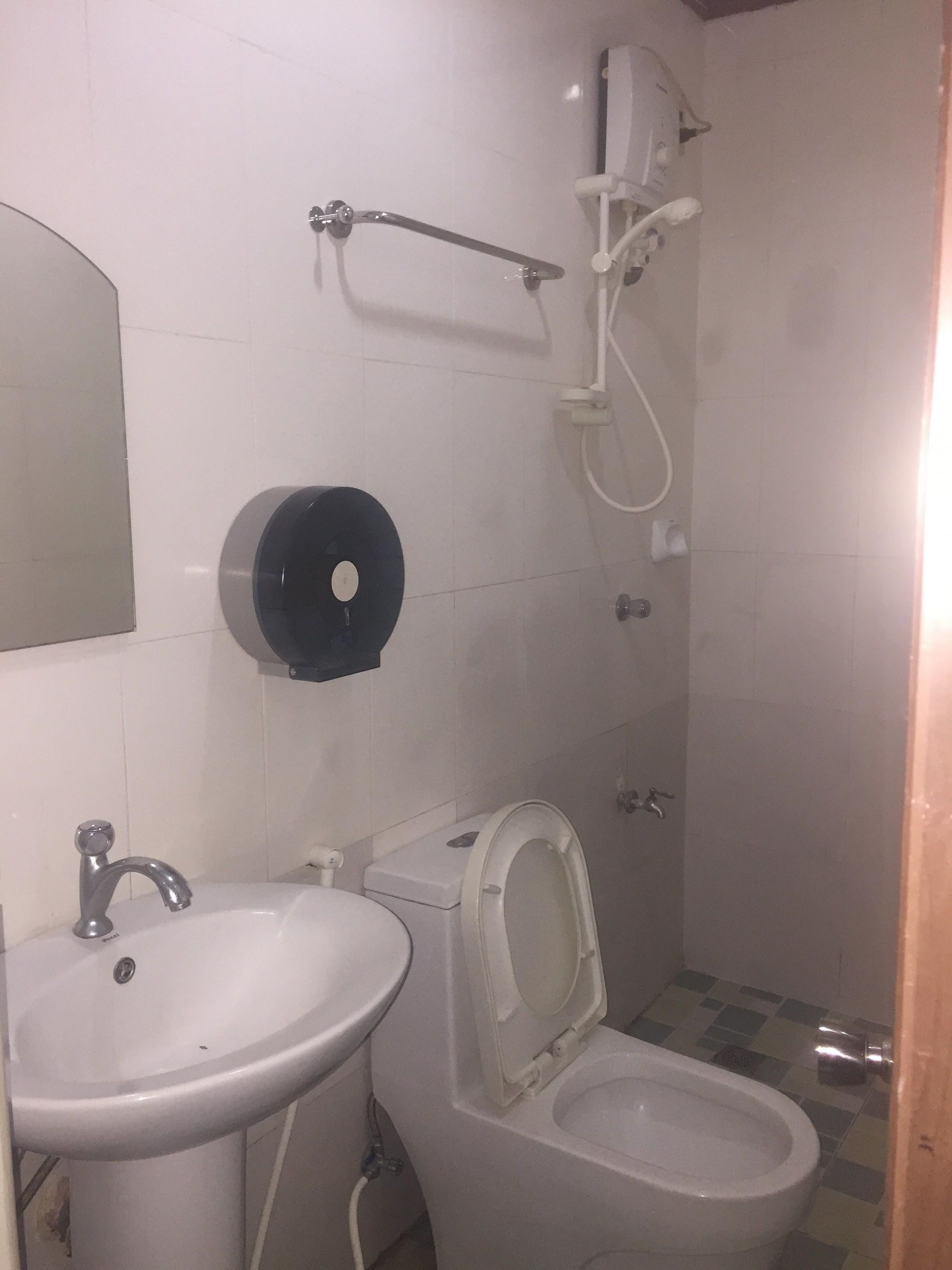 A small bathroom with a sink, toilet, and shower.