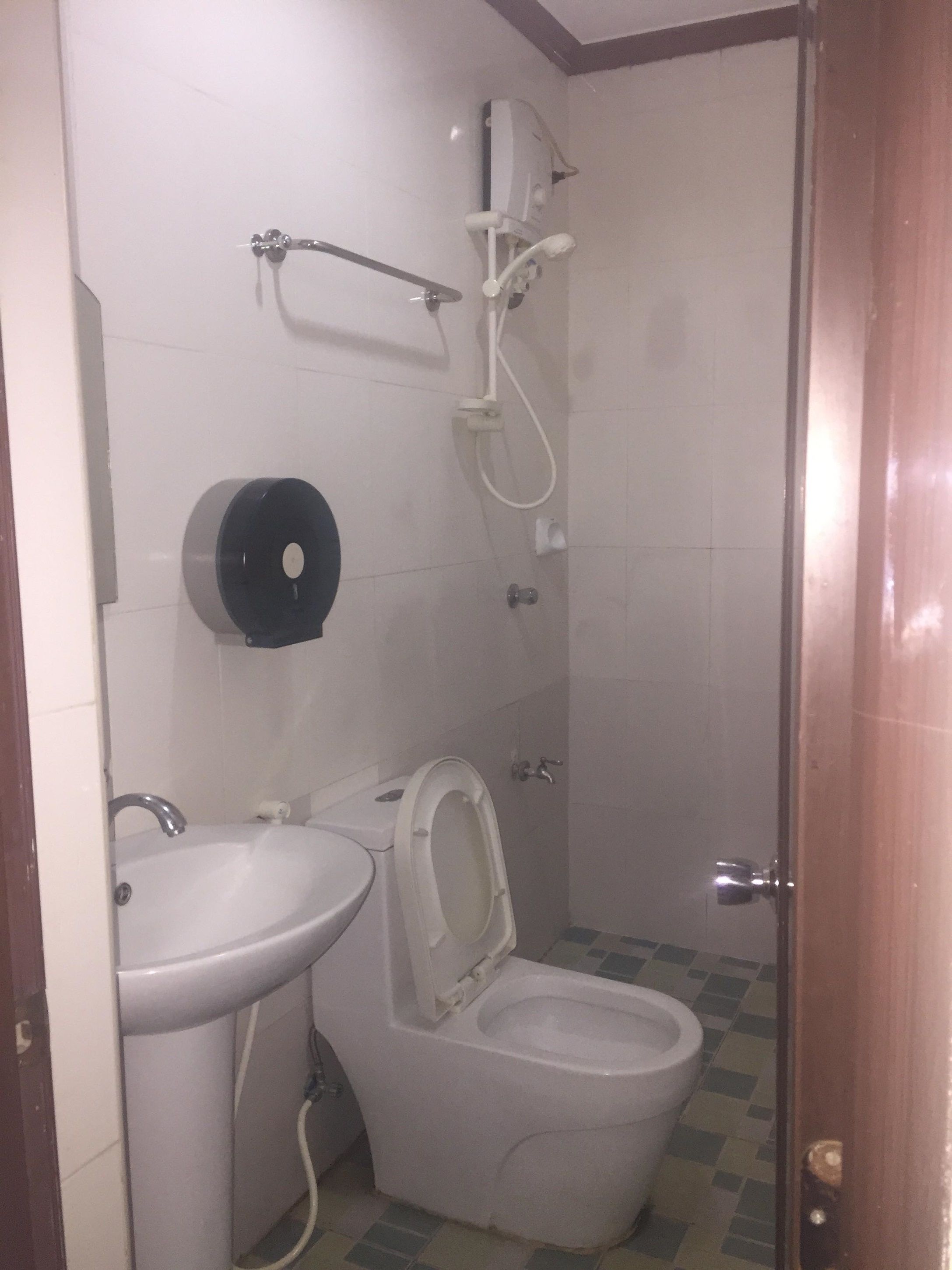 A bathroom with a toilet, sink, and shower.