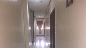 A long, narrow hallway with a shiny tiled floor and cream-colored walls.